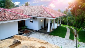 A house with a tiled roof, a covered porch, and a paved driveway. - Thompson Manor - A Luxury Villa in Galle (Akmeemana)