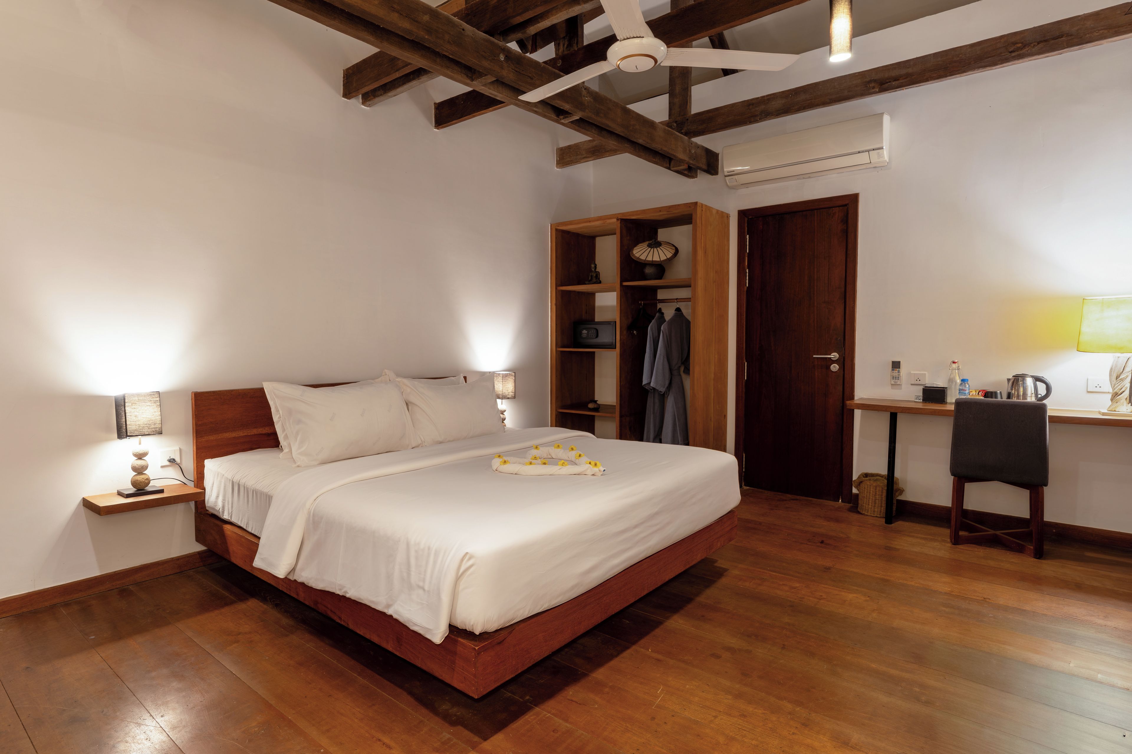 A bedroom with a wooden bed, a desk, and a wardrobe.