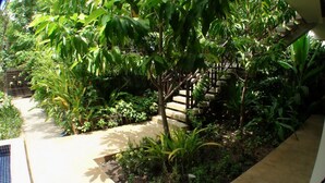A garden with a wooden staircase surrounded by lush greenery. - Enkosa Modern Villa (Siem Reap)