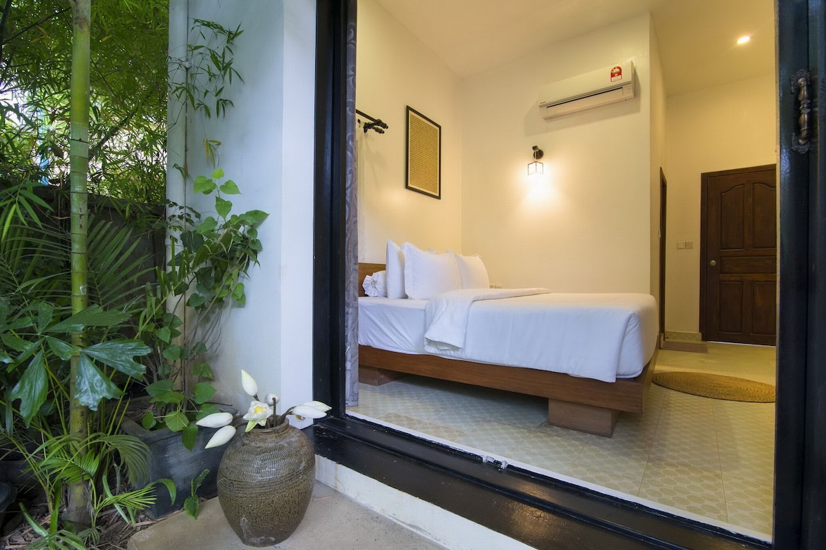 A bedroom with a bed, a window, and a door.
