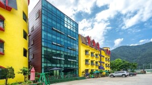 A modern hotel with a glass facade and a colorful exterior. - Inje Tourist Hotel (Inje)