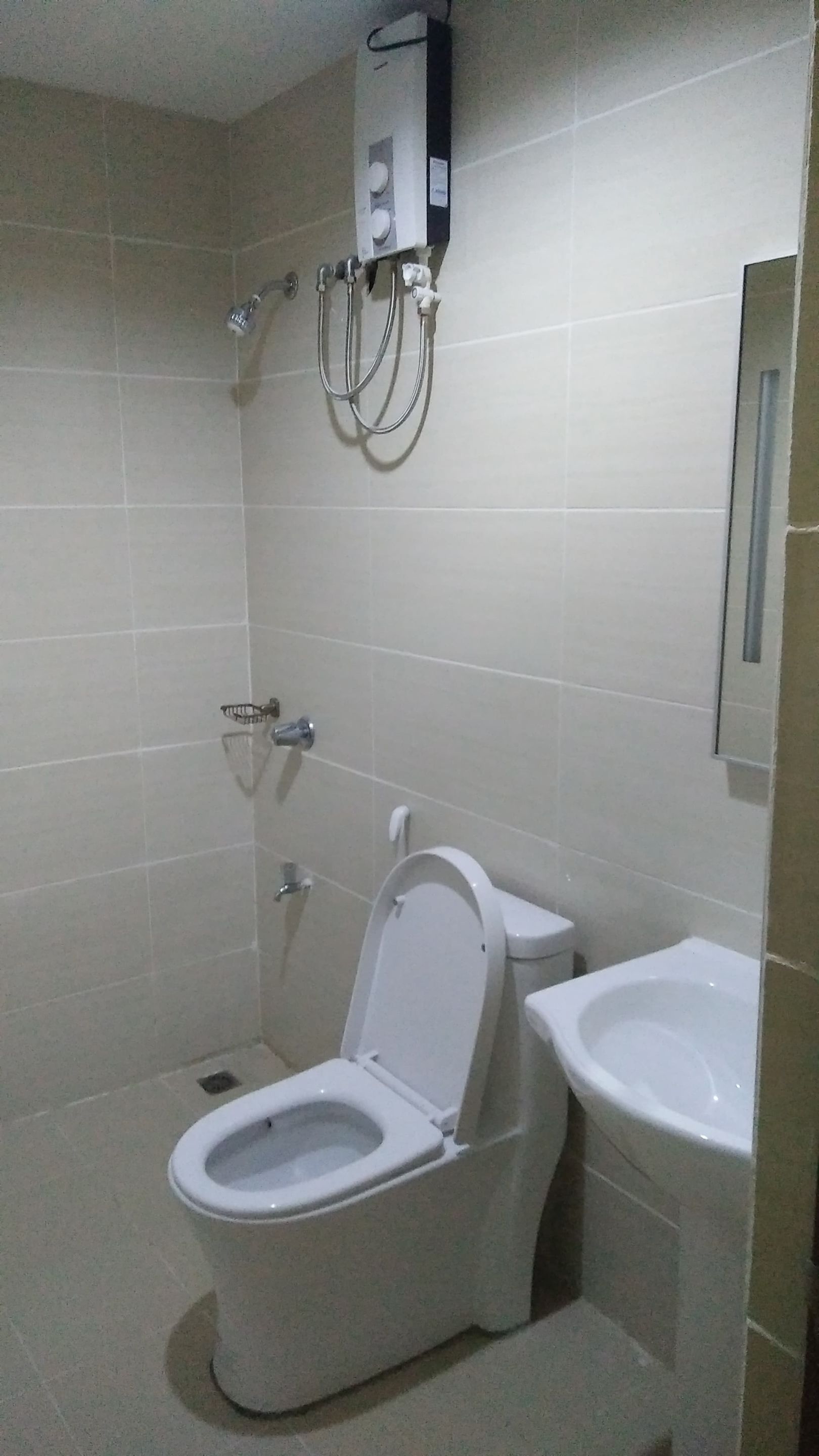 Un baño pequeño con azulejos, que incluye inodoro, bidé y ducha empotrada.