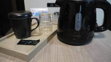 Eine schwarze elektrische Wasserwaerme mit digitaler Zeitanzeige auf einer Holztablett.