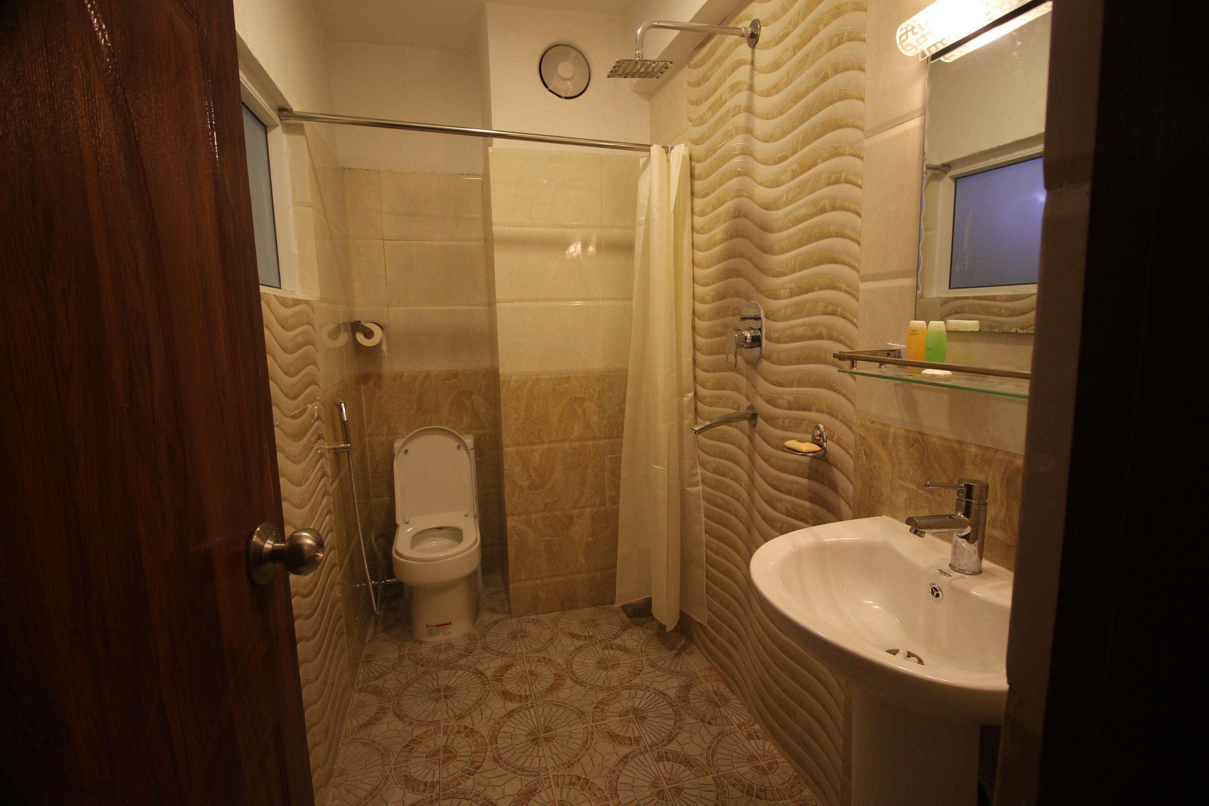 Une salle de bain avec des toilettes, une douche et un lavabo.