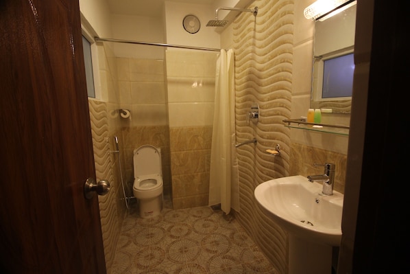 Un baño con inodoro, ducha y lavamanos.