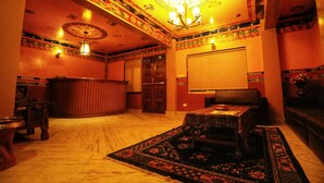 Une pièce au décor traditionnel, avec un tapis à motifs, un meuble en bois et un lustre.