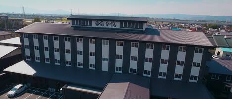 Un edificio de varios pisos con techo plano y un cartel con caracteres chinos.