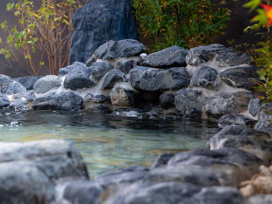 A natural rock formation with a clear water stream flowing over it.