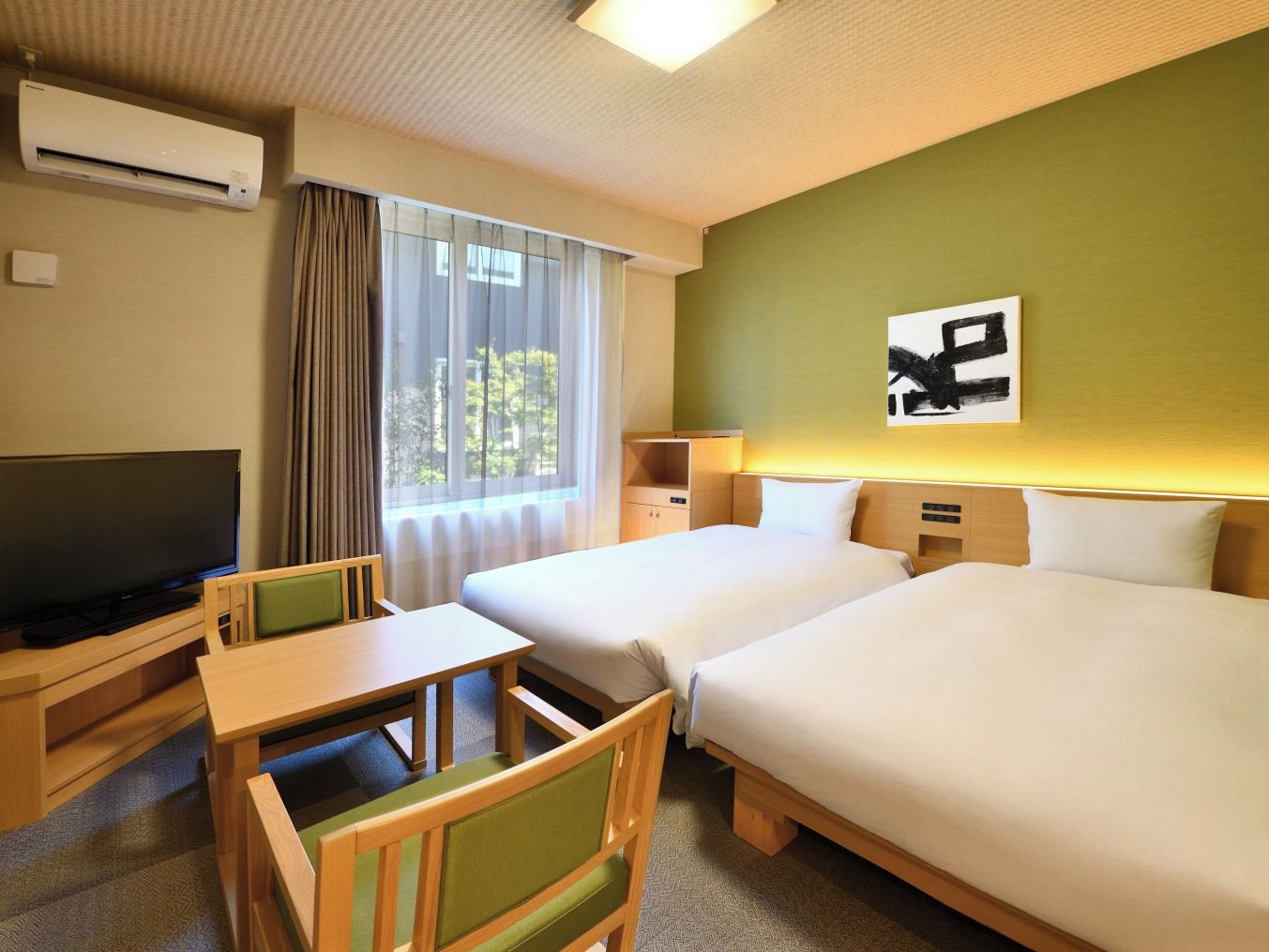 A hotel room with two beds, a television, a desk, and a chair.