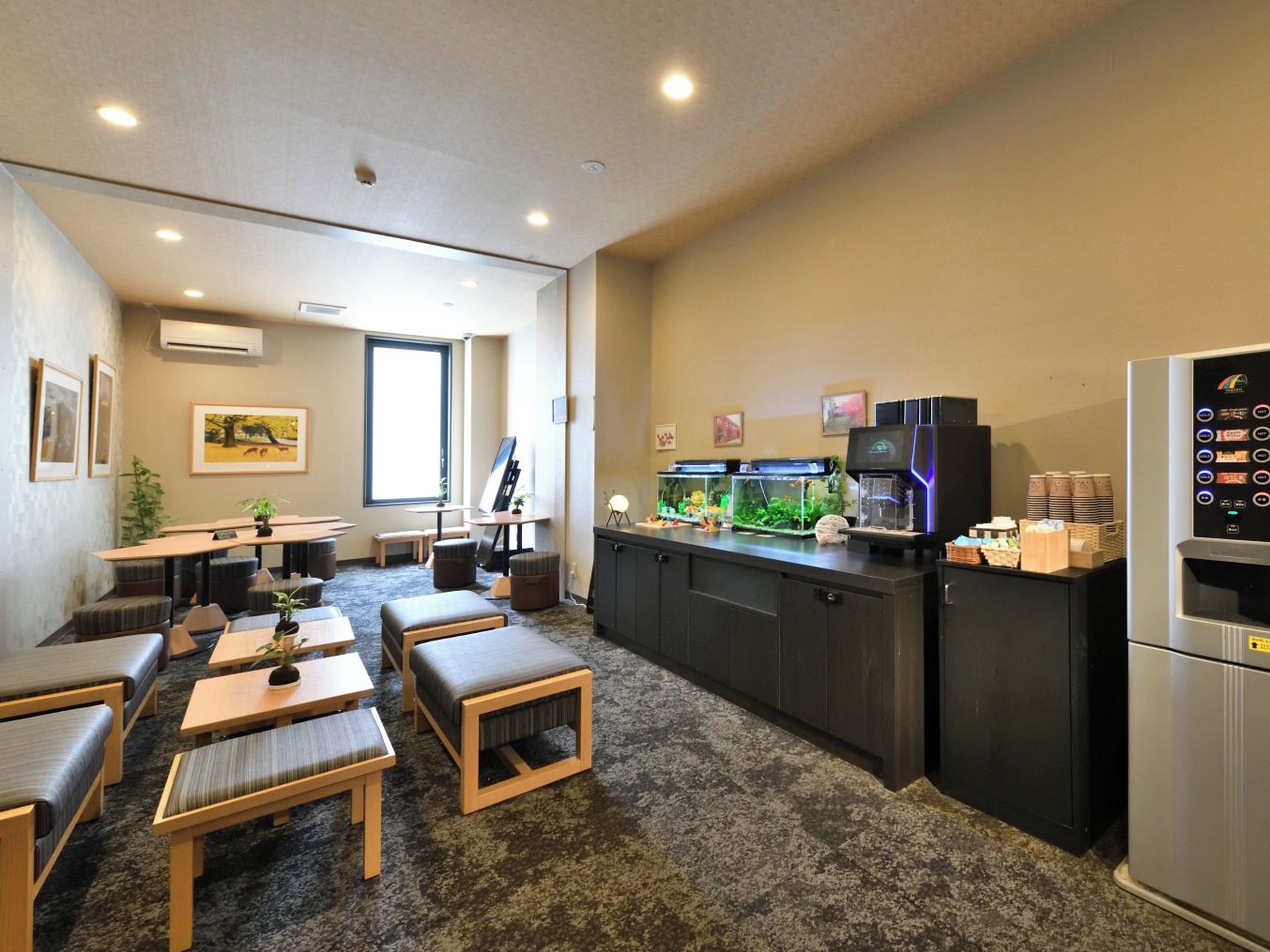 Une chambre moderne dotée d’un coin cuisine, de sièges et d’une machine à café.