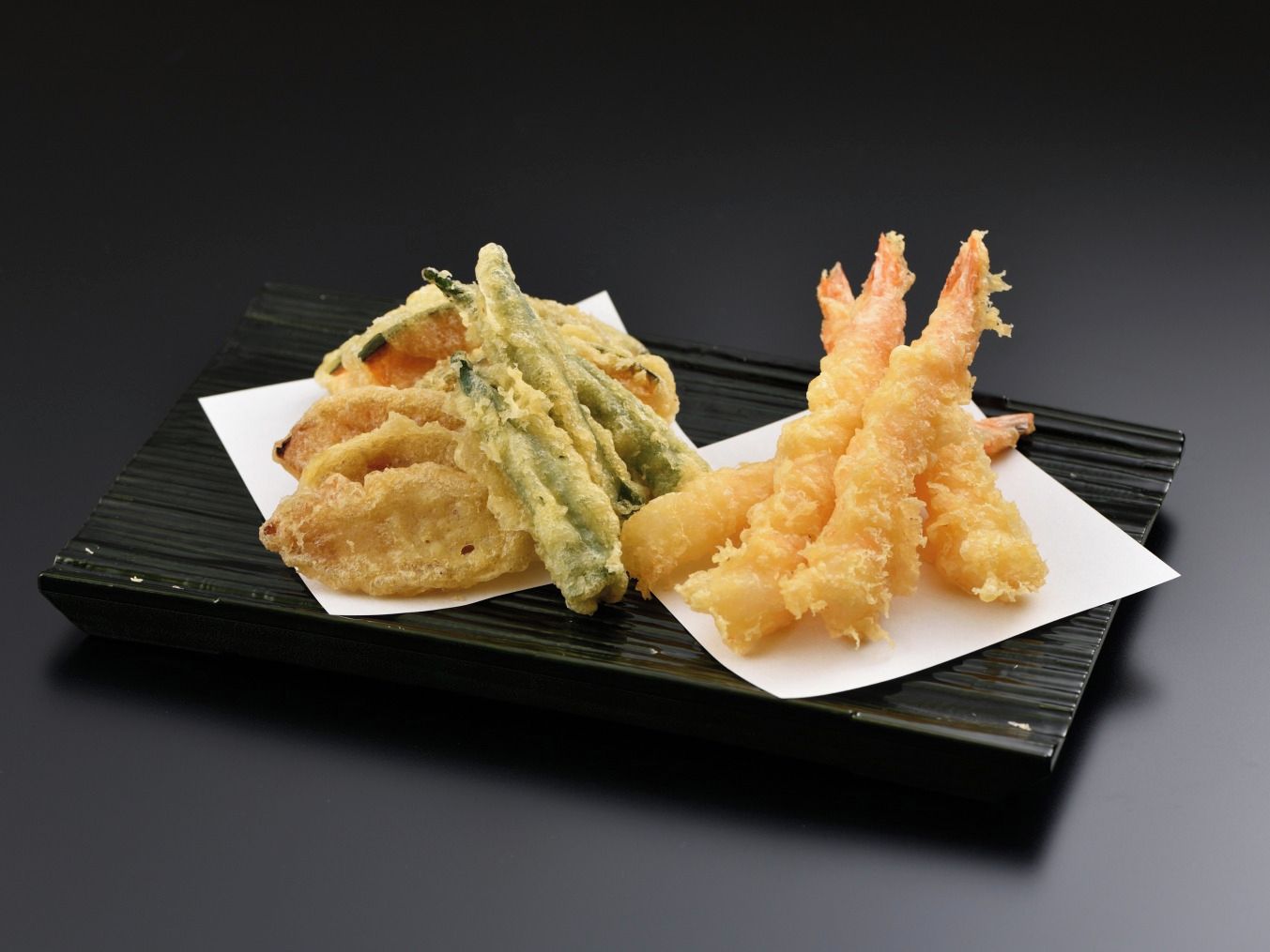 Un plato de tempura con camarones y verduras.