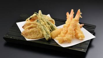 Un plato de tempura con camarones y verduras.