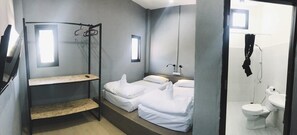 A small, compact room with a bunk bed, a single bed, a small table, and a window. - Bedbox Vientiane Hostel (Vientiane)