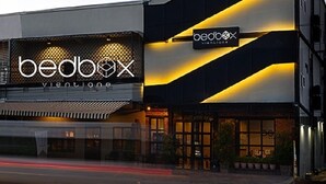 A modern building with a prominent 'bedbox' sign, featuring a geometric design and illuminated signage. - Bedbox Vientiane Hostel (Vientiane)