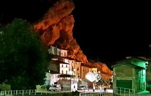 A building with multiple floors and a large, illuminated rock formation in the background. - APARTMENT 1 MENCIA (MIRADORES DEL ISASA) (Herce)