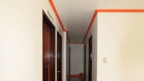 Un couloir avec des portes portant les inscriptions « SALLE 3 » et « SALLE 4 ».