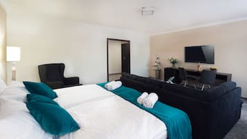 Una habitación de hotel con una cama grande, un sofá, un escritorio y un televisor.