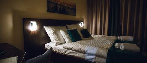 A hotel room with a bed, a desk, and a chair.
