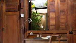 A wooden desk with a chair, a lamp, and a window with a view of greenery. - Yabbiekayu Eco Bungalows (Sewon)