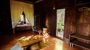 A wooden room with a bed, a table, and a bench. - Yabbiekayu Eco Bungalows (Sewon)