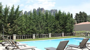 Ein Schwimmbecken mit Liegestühlen und einer Steinmauer.
