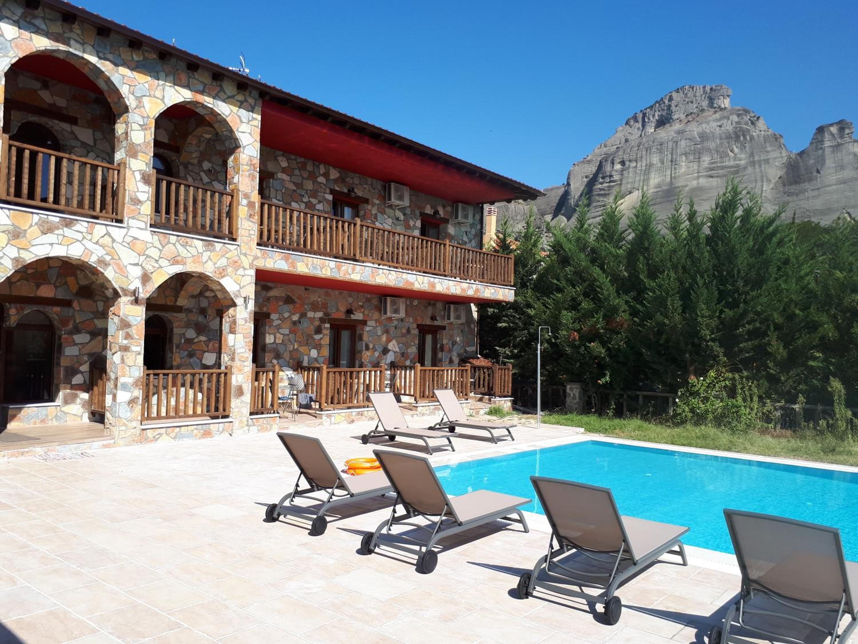 Ein Steinhaus mit Schwimmbad und Sitzgelegenheiten im Freien.