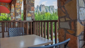 A stone-walled balcony with a view of rock formations and greenery. - Guesthouse Monastiri (Kalabaka)