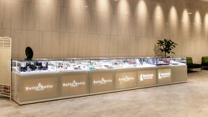 Een sieraden vitrine met meerdere glazen etalages met de tekst 'BellaBella jewelry', in de hotelentree.