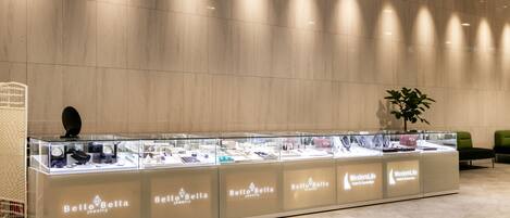 A jewelry display counter with multiple glass cases labeled "BellaBella jewelry" in a hotel lobby.