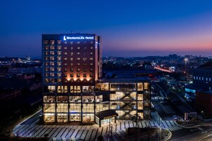 A WesternLife Hotel with a modern glass facade, multiple floors, and a prominent sign.