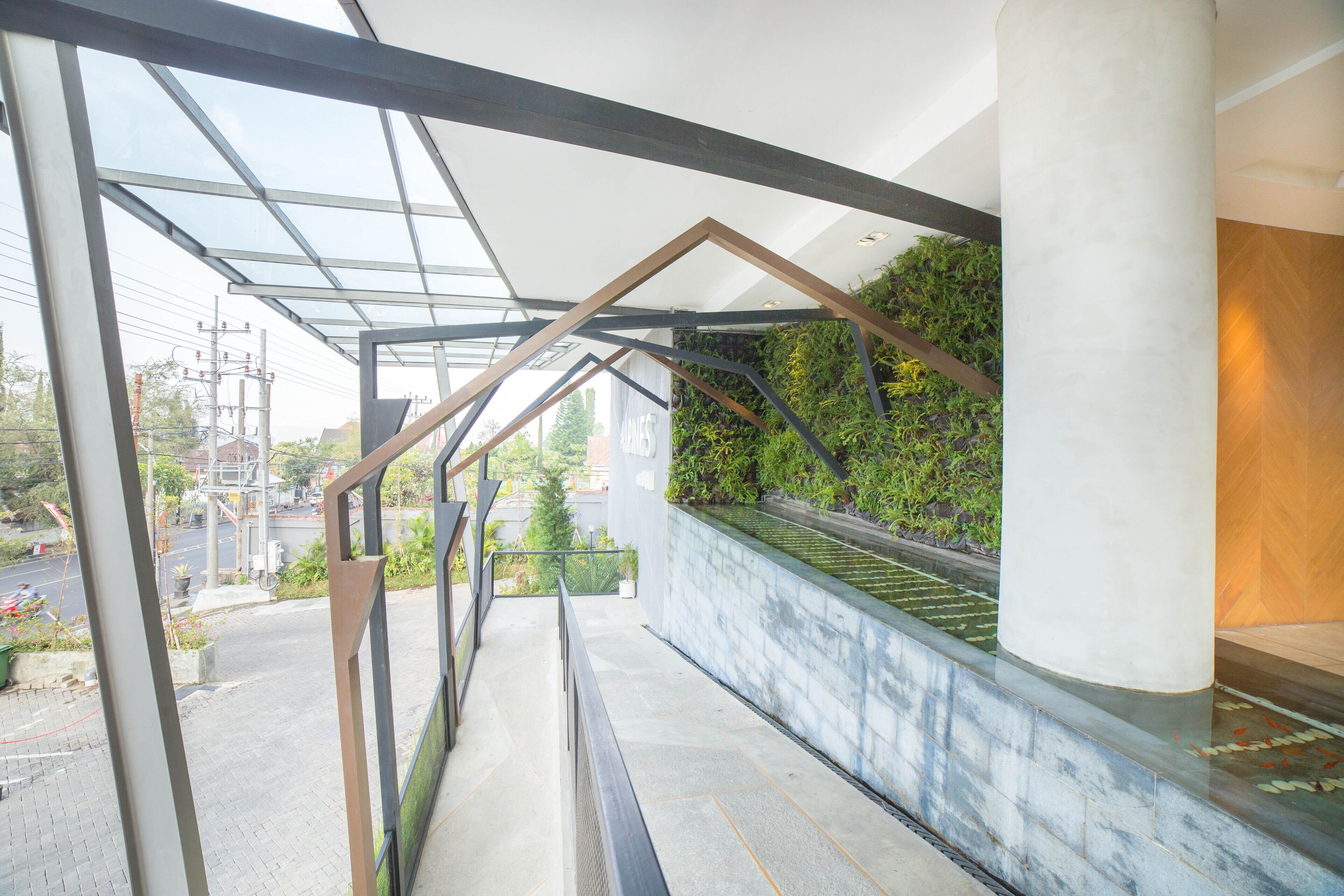 A modern architectural design with a glass facade, a metal framework, and a green wall with plants.