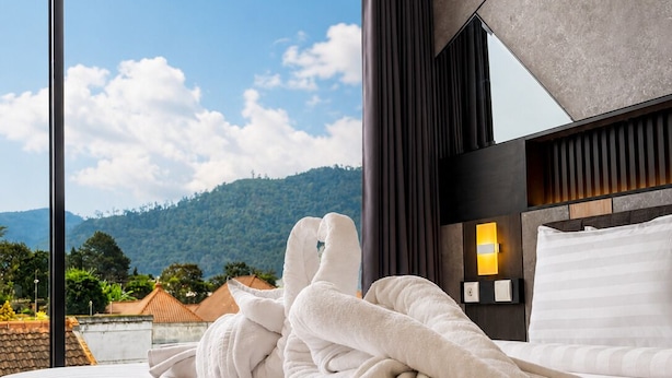 Habitación de hotel con una cama grande, vistas a la montaña y un diseño moderno.