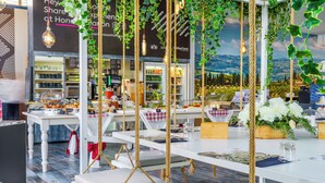 A restaurant with white tables, rope swings, and hanging greenery. - San Francesco Country Resort (Rosignano Marittimo)