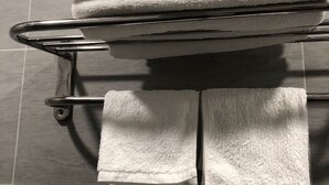 A metal towel rack with three folded white towels. - Happy Homes 95 Le Thi Rieng (Ho Chi Minh City)