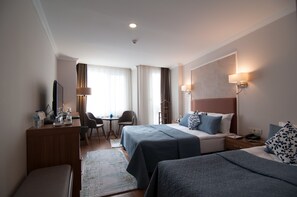 Comfort Triple Room | Ylelliset vuodevaatteet, minibaari, tallelokero huoneessa, työpöytä