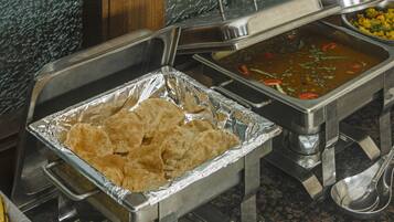 Un aparador de buffet amb safates d'alumini que contenen tortillas i un plat de sopa.