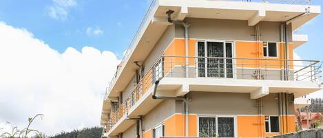 A multi-story building with balconies, railings, and windows.
