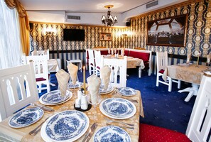 A dining area with tables set for two, featuring blue and white patterned tableware.