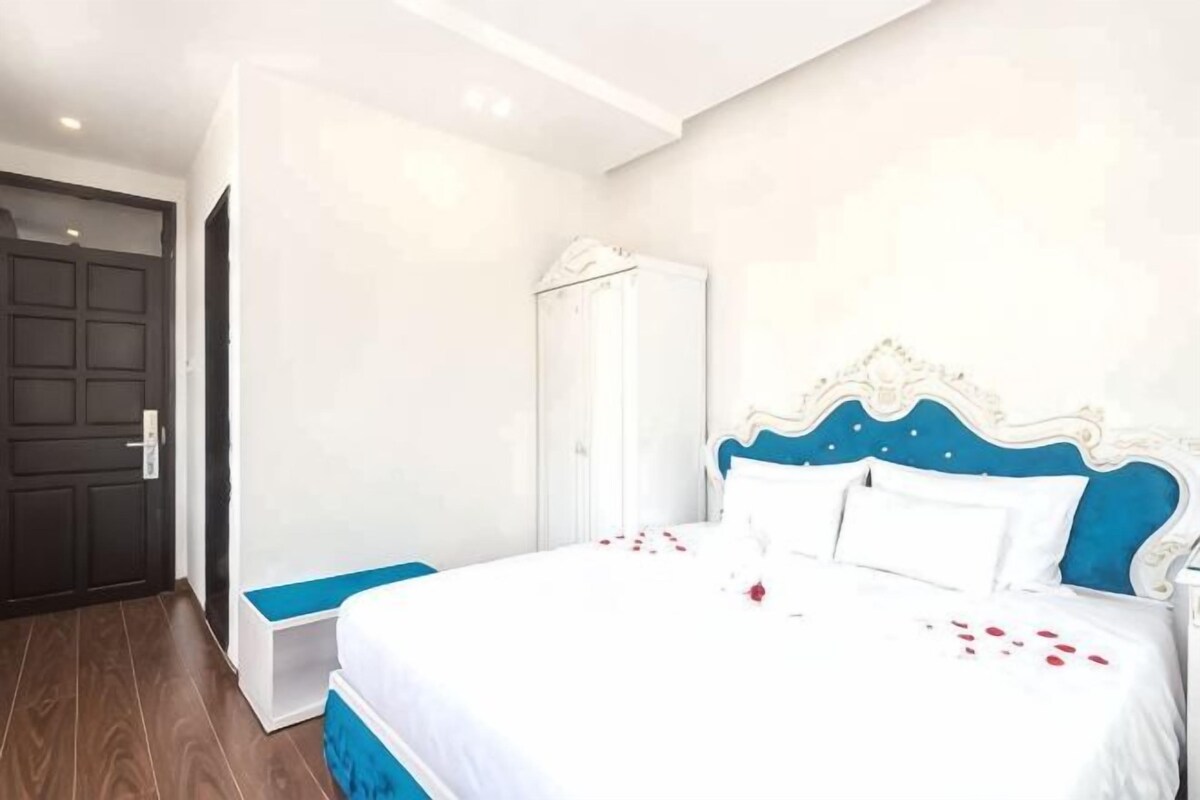 A bedroom with a bed, a wardrobe, and a bench.