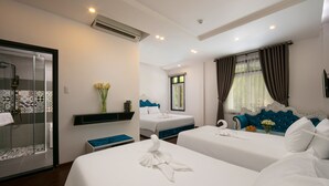 A hotel room with a shower, two beds, a blue headboard, and a window with curtains. - Hoian Nostalgia Hotel & Spa (Da Nang)