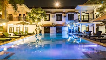 Una piscina al aire libre, sombrillas, tumbonas