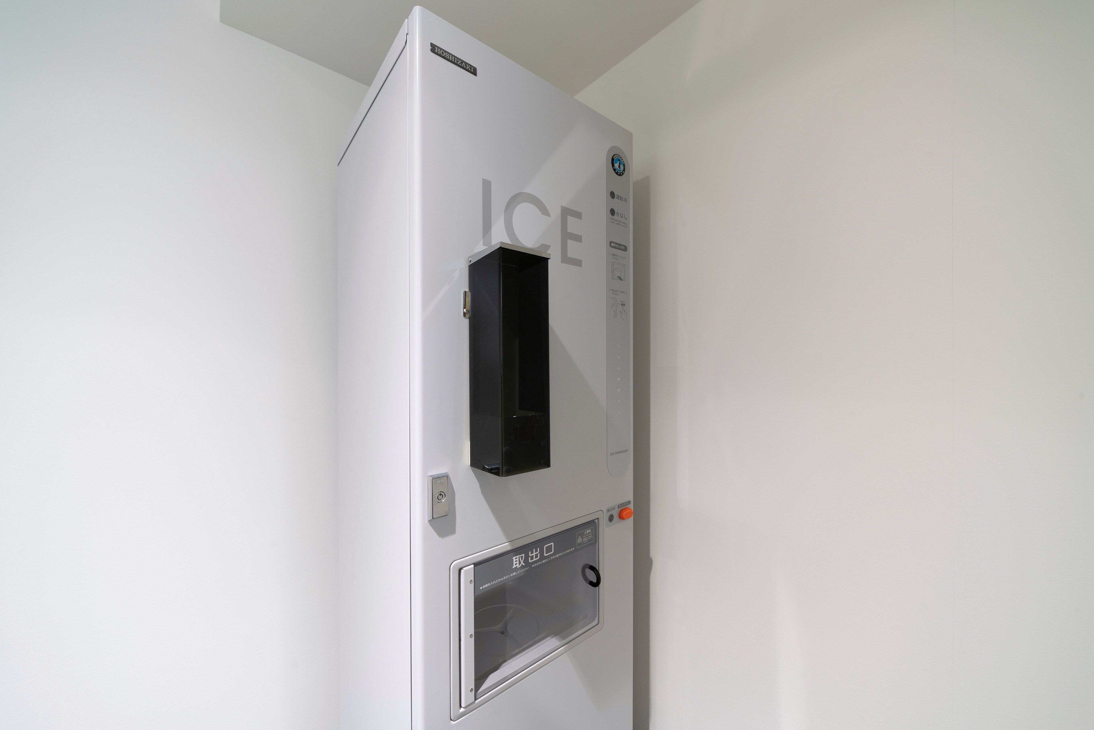 A modern, white ice dispenser with a digital display and a control panel.