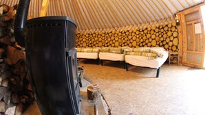Un intérieur chaleureux avec un poêle à bois, un ensemble de canapés et un mur en rondins.