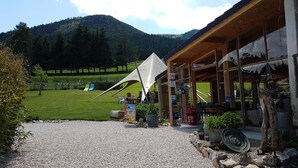 Un bâtiment avec une allée en gravier, une tente et une vue sur la montagne.