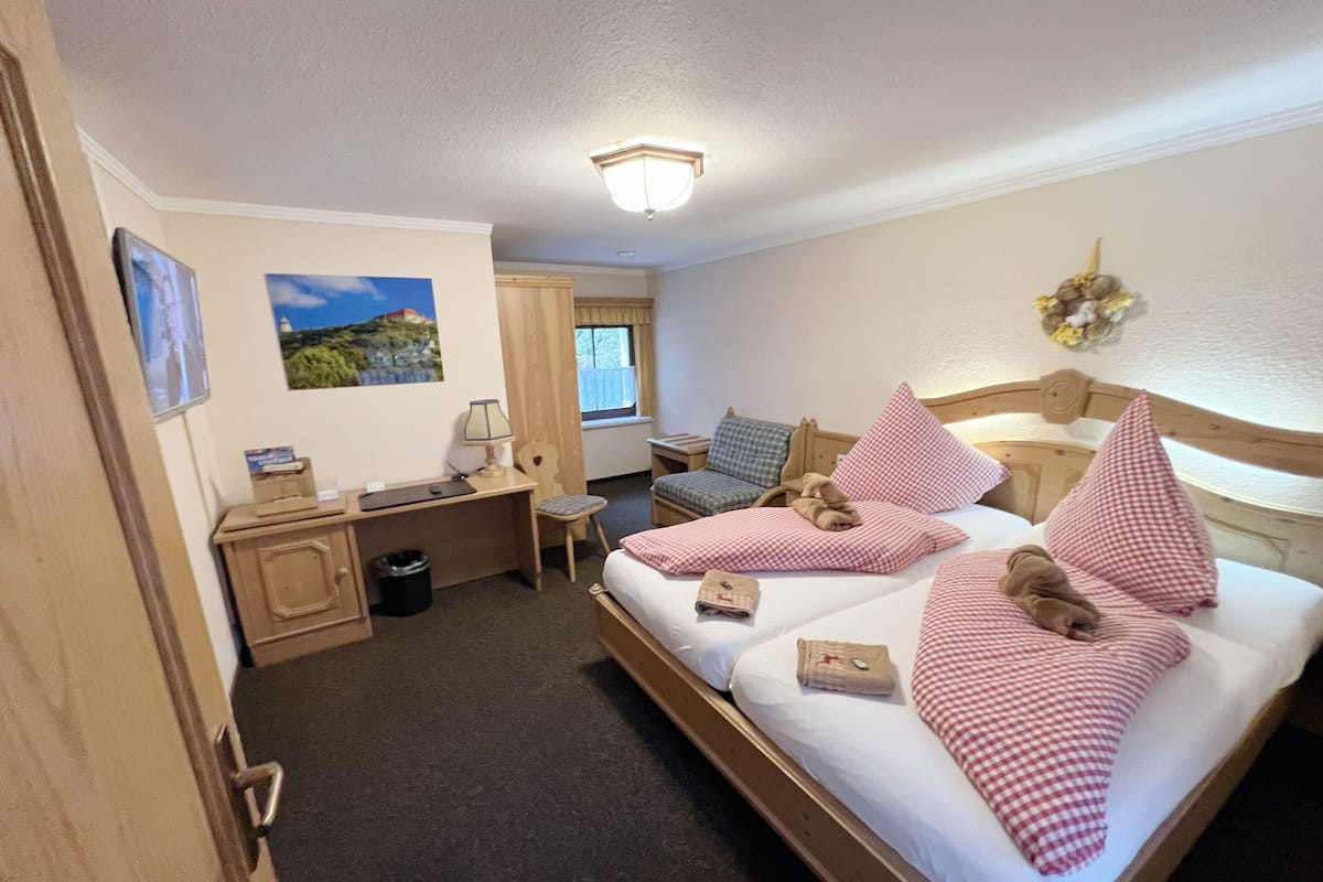 Een hotelkamer met een groot bed, een bureau, een stoel en een kleine tafel.