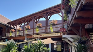 A wooden balcony with hanging flower baskets and a sign for Hotel Sonnenkalf.