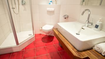 Un baño con ducha, inodoro y bañera.