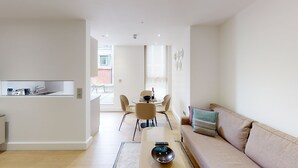 Una sala de estar moderna con un sofá, una mesa de centro y un comedor con sillas y una mesa.