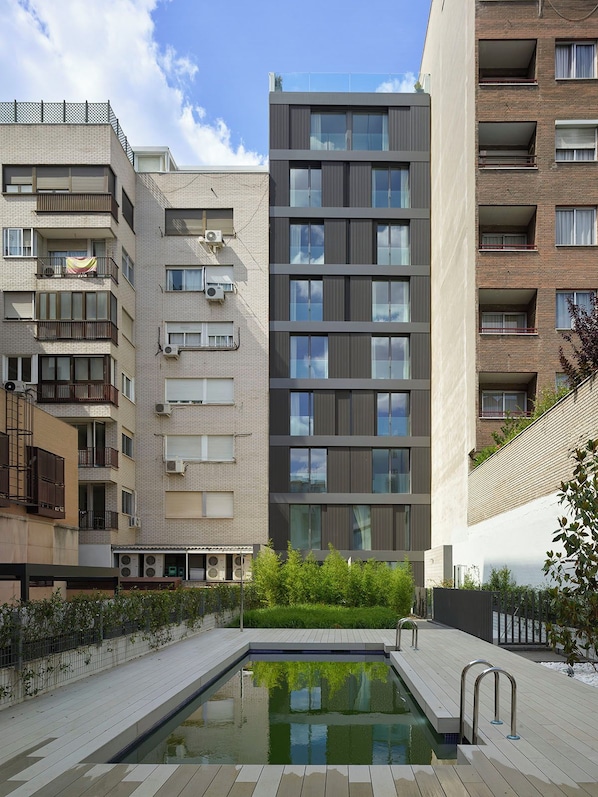 A modern apartment building with a rooftop pool area.