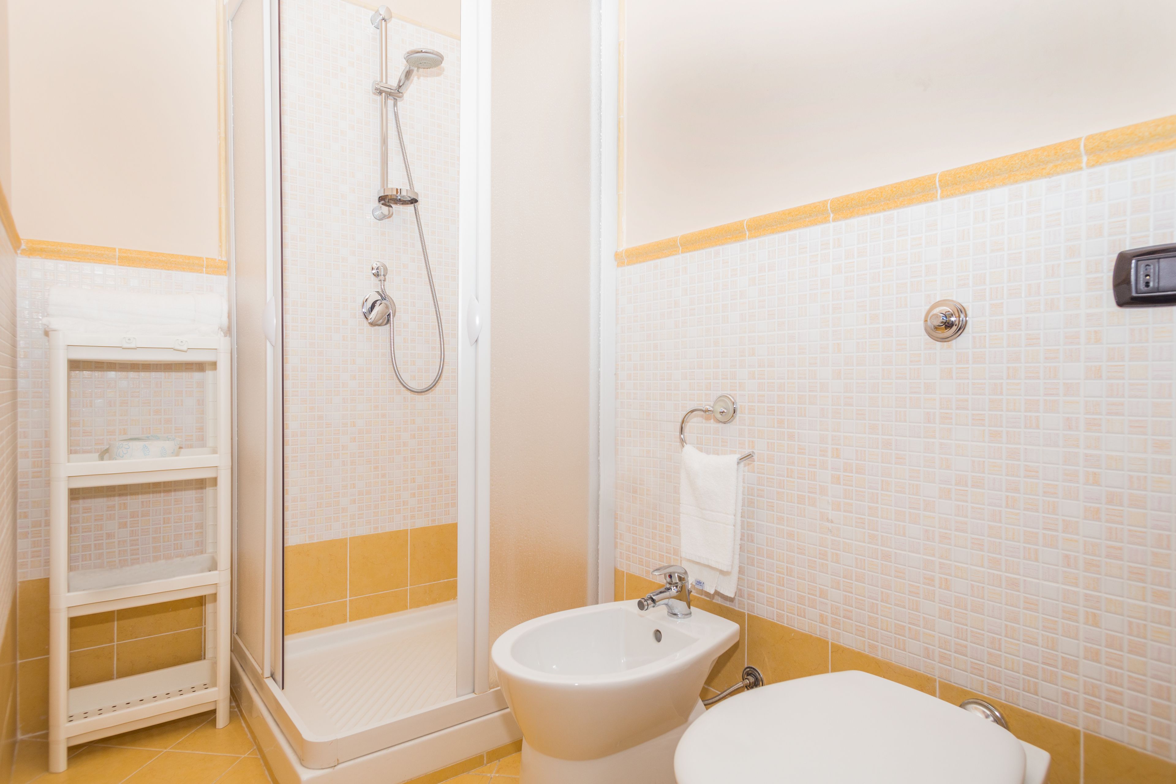 Een badkamer met een douche, wastafel en toilet.
